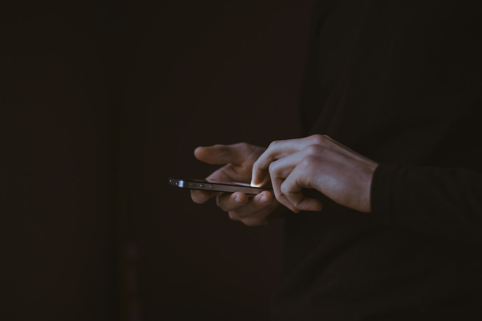 Teen silhouette holding a smartphone at night, illustrating a social media addiction lawsuit